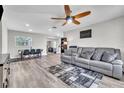 Spacious living room featuring wood-look floors, gray sectional, fan, and neutral color palette at 7033 Budapest Way, Orlando, FL 32822