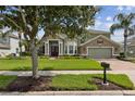 Two-story home featuring stone accents, an attached two-car garage, and a well-maintained front yard at 724 Duff Dr, Winter Garden, FL 34787