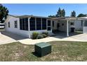 Bright home exterior featuring a carport, screened-in porch, and well-kept lawn at 816 Polo Park East Blvd, Davenport, FL 33897