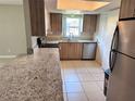 Well-lit kitchen featuring granite countertops, stainless steel appliances, and modern wood cabinets at 9831 Barley Club Dr # 8, Orlando, FL 32837