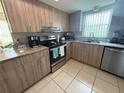 Bright kitchen features granite counters, stainless steel appliances, and wood-grain cabinetry at 9831 Barley Club Dr # 8, Orlando, FL 32837