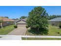Aerial view of the house, featuring a brick paver driveway, landscaping, and a well-manicured lawn at 10138 Lenox St, Clermont, FL 34711