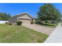 View of the home's front, showcasing the brick paver driveway, and well-maintained lawn at 10138 Lenox St, Clermont, FL 34711