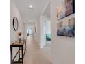 Bright hallway with neutral tile, white walls and entry to the living spaces at 11284 Amber Ridge Dr, Zellwood, FL 32798