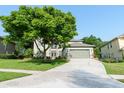 Inviting home with well-kept lawn and mature trees, featuring an attached two-car garage at 1161 Coastal Cir, Ocoee, FL 34761