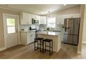 Bright kitchen featuring white cabinets, stainless steel appliances, island with stool seating, and updated fixtures at 1220 Dustin Dr, Lady Lake, FL 32159