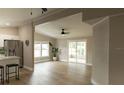 Open concept living room with wood flooring, ceiling fan, natural light, and sliding doors to screened in patio at 1220 Dustin Dr, Lady Lake, FL 32159