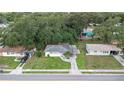 Aerial view of a single-story home, showcasing the surrounding neighborhood and mature trees at 1244 Woodland Ave, Lakeland, FL 33801