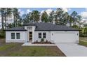 Beautifully landscaped one-story home with a two-car garage and modern architectural details at 13420 Sw 77Th Ave, Ocala, FL 34473