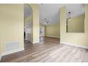 Spacious living room featuring wood flooring, neutral paint, ceiling fan, and window with natural light at 145 Henue Ct, Davenport, FL 33896