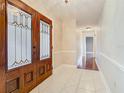 Inviting foyer featuring elegant tile flooring and double doors with decorative glass panels at 148 Tarrytown Trl, Longwood, FL 32750