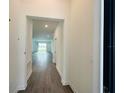 Inviting hallway with wood-style flooring, leading to the home's bright and open living spaces at 1590 Contentment Loop, Kissimmee, FL 34744