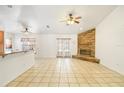 Open living space with tile flooring, a stone fireplace, and a view of the kitchen with bar seating at 1621 Sunny St, Kissimmee, FL 34741