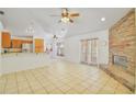Spacious living area featuring a stone fireplace, tile floors, and easy access to the kitchen and patio at 1621 Sunny St, Kissimmee, FL 34741