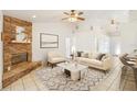 Bright living room featuring a beautiful stone fireplace, modern furnishings, and high ceilings with ceiling fans at 1621 Sunny St, Kissimmee, FL 34741