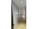 Hallway with neutral paint, ceramic tile floors, and an open doorway leading to another room at 1695 E Horatio Ave, Maitland, FL 32751
