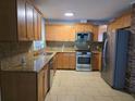 Traditional kitchen featuring stainless steel appliances, tile flooring, and granite countertops at 1695 E Horatio Ave, Maitland, FL 32751