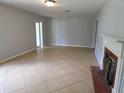 Neutral living room with tile floors, decorative fireplace and mantle, and natural light at 1695 E Horatio Ave, Maitland, FL 32751