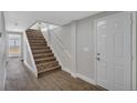 Entryway with a white front door, staircase, and wood-look flooring at 1840 Lillian Dr, St Cloud, FL 34771