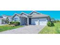 A well-maintained single Gathering home features a brick driveway and inviting landscaping at 18851 Rawson St, Orlando, FL 32827
