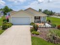 Well-maintained home featuring a manicured lawn, inviting entrance, and an attached two-car garage at 2167 Kerwood Loop, The Villages, FL 32162