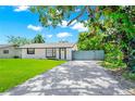 Inviting single-story home with charming curb appeal, featuring a well-manicured lawn and a brick paved driveway at 228 Ring Rd, Orlando, FL 32811