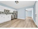 Open-concept kitchen with stainless steel appliances, complemented by modern cabinets and a flowing layout into dining area at 228 Ring Rd, Orlando, FL 32811