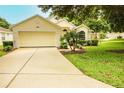 Attractive one-story home boasting a manicured lawn, driveway, and attached two-car garage at 2309 Edmonton Ct, Clermont, FL 34711