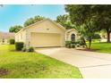 Lovely one-story home featuring a lush green lawn, mature trees, and a spacious driveway at 2309 Edmonton Ct, Clermont, FL 34711