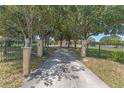 Long, private driveway leading to a property with a gated entrance and mature trees at 2500 Derby Dr, Kissimmee, FL 34744