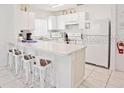 Bright white kitchen features modern countertops, cabinets, stainless steel appliances, and bar seating at 2524 Hamlet Ln, Kissimmee, FL 34746