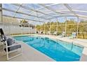 A screened-in pool area with lounge chairs and a clear blue swimming pool perfect for relaxation at 2524 Hamlet Ln, Kissimmee, FL 34746