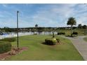 Golf course view including putting green, lake, and palm trees under a sunny sky at 3621 Atrium Dr # U-4, Orlando, FL 32822