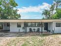 Charming single-story home exterior with seating area, featuring a manicured lawn and inviting front entrance at 3788 N Econlockhatchee Trl, Orlando, FL 32817
