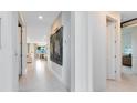 Bright hallway featuring modern lighting and contemporary artwork, leading to various rooms at 4007 Marbury Ct, Davenport, FL 33837