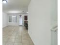Bright living room featuring tile flooring, a modern chandelier, and an open layout to the kitchen area at 4450 Capital Blvd, St Cloud, FL 34769
