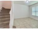 Carpeted staircase with white railing leads to the upper level, providing a clear view of the home's layout at 4450 Capital Blvd, St Cloud, FL 34769