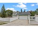 Charming two-story home featuring a well-manicured lawn and white picket fence, complemented by an attached two-car garage at 4527 Sandhurst Dr, Orlando, FL 32817