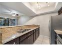 Bright kitchen featuring granite countertops, stainless steel appliances and tiled floor at 5071 Eaglesmere Dr # C01, Orlando, FL 32819