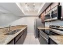 Modern kitchen featuring granite countertops, stainless steel appliances, and tiled floors at 5071 Eaglesmere Dr # C01, Orlando, FL 32819