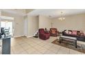 Open-concept living room with tile flooring, chandelier, and comfortable seating arrangement, ideal for relaxation at 510 Lobelia Dr, Davenport, FL 33837