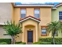 Attractive townhome with a tiled roof, neat landscaping, and an arched entryway at 540 Monroe Cir, Davenport, FL 33896