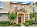 Inviting townhome with a tiled roof, well-kept lawn, and decorative shrubbery at 540 Monroe Cir, Davenport, FL 33896