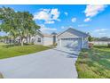 Charming single-story home with a well-manicured lawn and a long driveway leading to an attached two-car garage at 560 Viceroy Ct, Kissimmee, FL 34758
