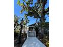 Charming walkway leading to a white house with beautiful landscaping and a vintage lamp post at 629 Helen St, Mount Dora, FL 32757