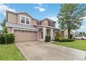 Charming two-story home featuring a red front door, attached garage, and well-maintained landscaping at 7551 Bear Claw Run, Orlando, FL 32825