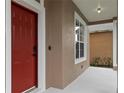 Close-up of the red front door and adjacent window, highlighting the home's entry and facade at 7551 Bear Claw Run, Orlando, FL 32825