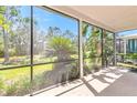 Relaxing screened patio overlooking a lush green backyard and mature landscaping at 7710 Linkside Loop, Reunion, FL 34747