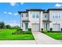 Two-story townhome with a blue front door, two-car garage, and landscaped front yard at 809 Benoi Dr, Davenport, FL 33896