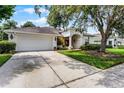 Inviting single-Gathering home featuring a well-kept lawn, driveway, garage, and a charming arched entrance at 821 Shallow Brook Ave, Winter Springs, FL 32708